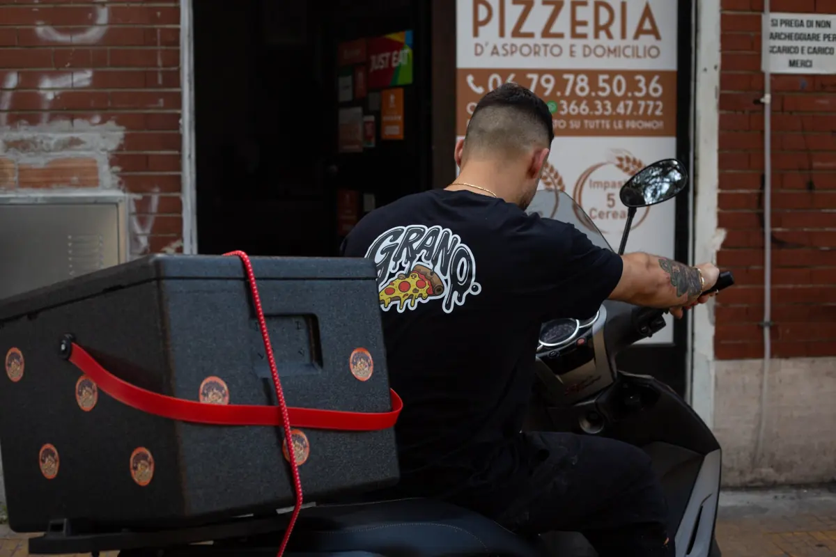 Il rider di Grano parte in motorino dalla pizzeria con le pizze nel box termico